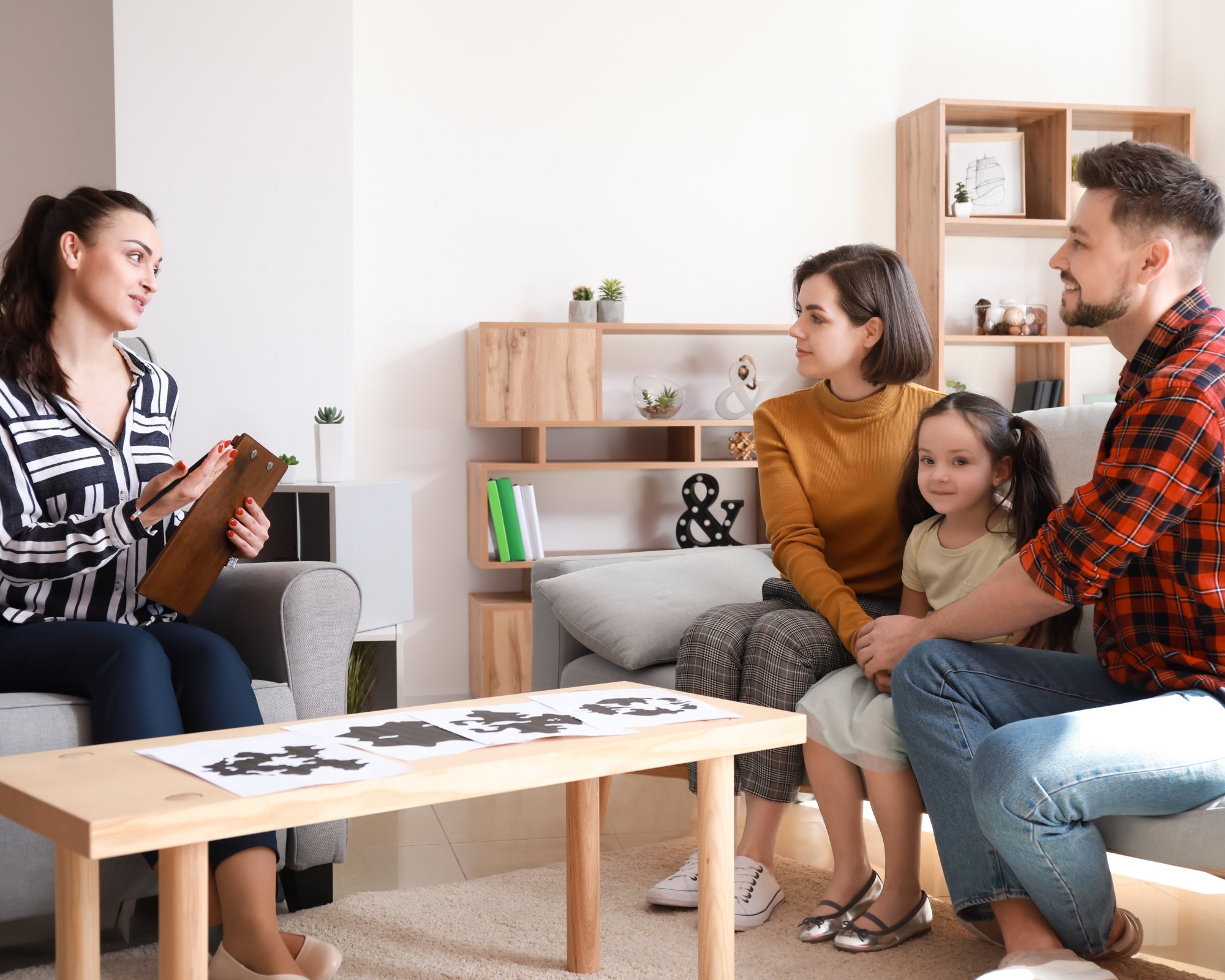 Een begeleider bespreekt de diagnose met ouders en hun kind tijdens psycho-educatie bij Praktijk Ontpop in Putte